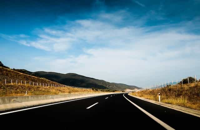 an empty highway under the blue sky