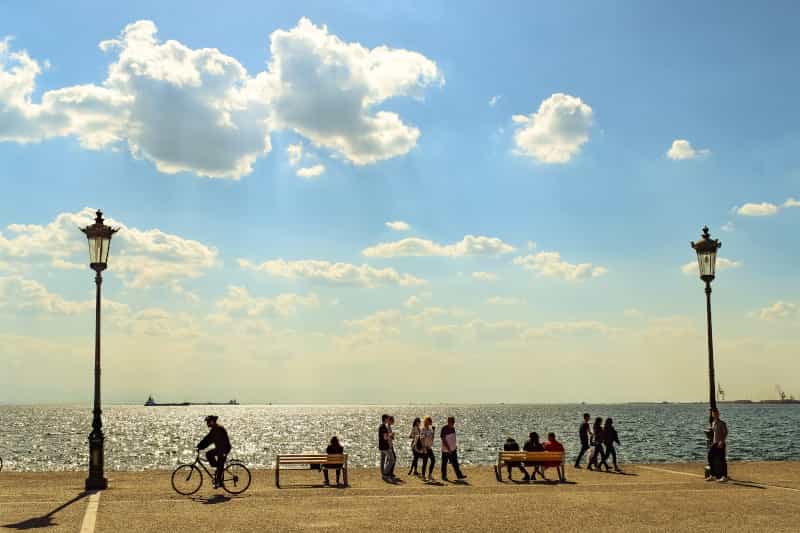 People strolling at Thessaloniki's promenade on a sunny afternoon