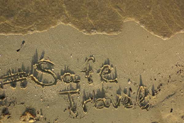 safe travel is written in the sand