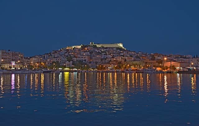 Una vista panoramica di Kavala di notte dal mare