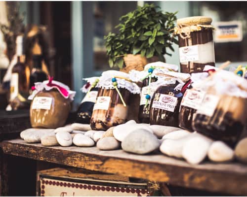 Ein Holztisch mit Gläsern mit griechischem Honig und Löffelbonbons
