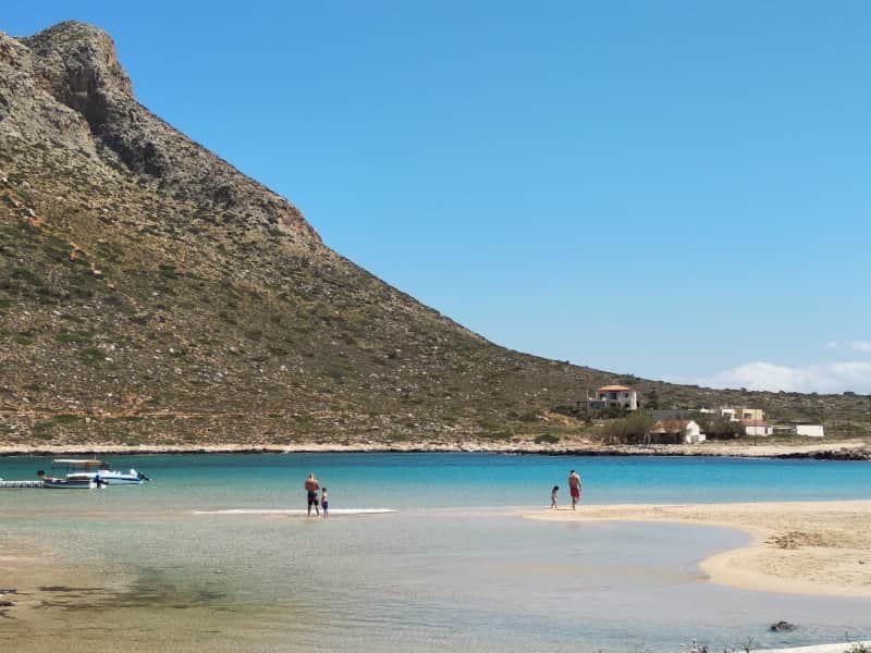 Eltern spazieren mit ihren Kindern am Sandstrand Stavros in Chania Kreta entlang