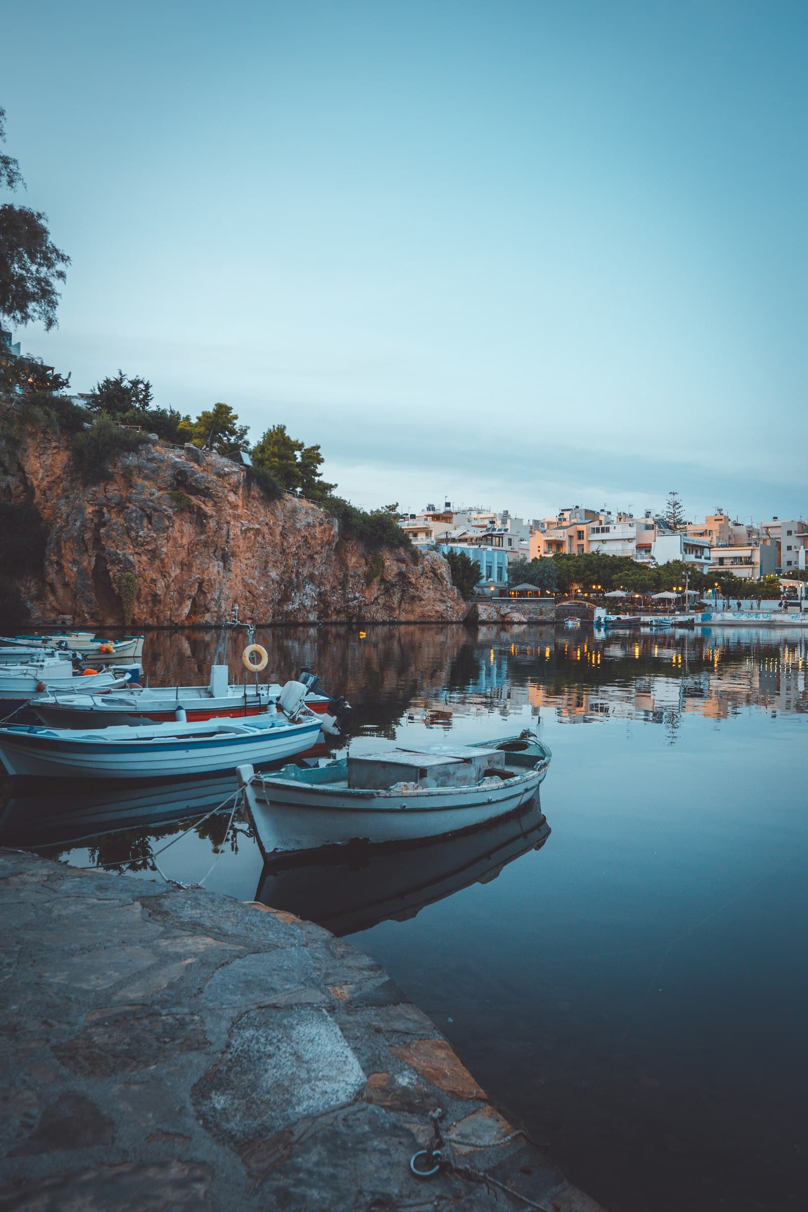 Agios Nikolaos car rental — a white and blue boat on calm water at Agios Nikolaos, Crete, Greece