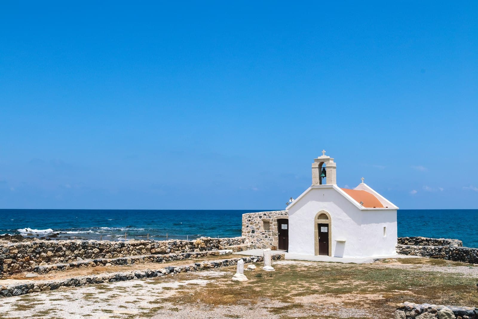 Hersonissos car rental — a white and red seafront building under a blue sky at Hersonissos, Crete, Greece