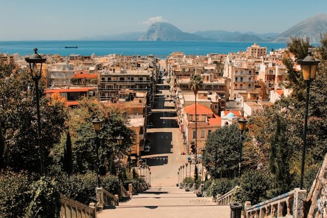 A photo of a street in Patras with views of the sea and the mountains across the land