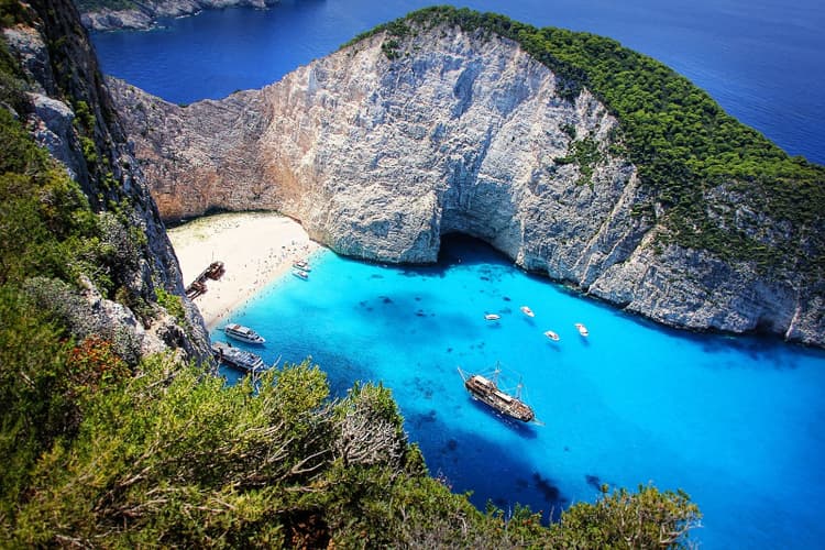 An aerial view of navagio beach, with a shipwreck on its white sand shore and turquoise waters
