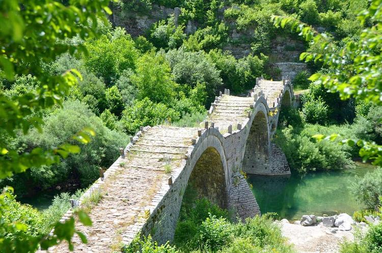 the stone arch bridge of Zachoria in Epirus, surrounded by lush vegetation