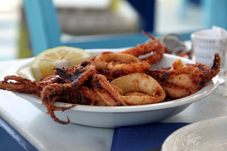 A plate with fried calamari and a slice of lemon