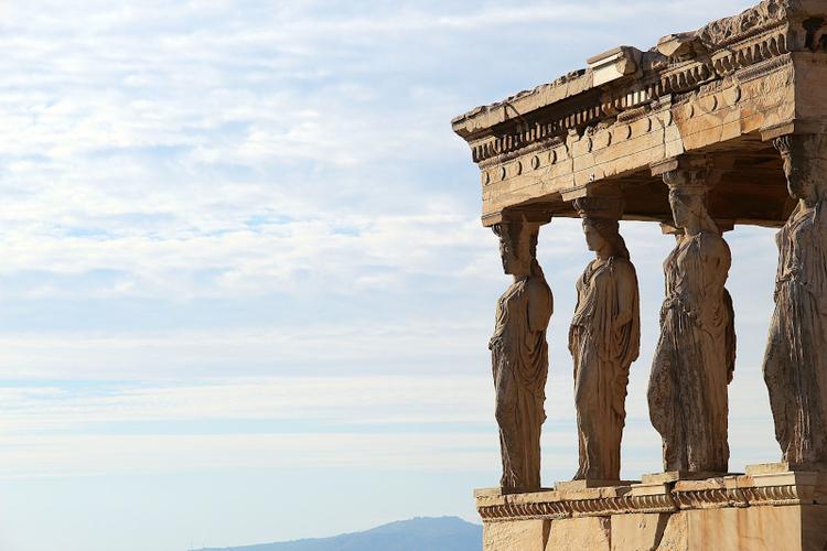 The front of the Erechtheion temple in Acropolis with the Caryatids statues as columns in the Athenian sky